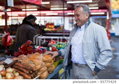 Middle aged man buying vegetables Middle aged man buying vegetables 93775429