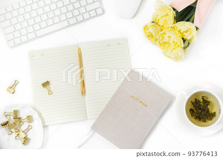 Office Desk table. Flat lay, top view. Home office workspace of a freelancer or blogger. A keyboard, a mouse, a bunch of tulips, a Cup of green tea, and a Notepad with a pen. 93776413