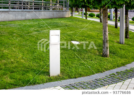 flat led lantern of ground garden in city park with trees and green lawn landscape near stone tile walkway with granite curb, cityscape with urban lighting on grass, nobody. flat led lantern of ground garden in city park with trees and green lawn landscape near stone tile walkway with granite curb, cityscape with urban lighting on grass, nobody. 93776686