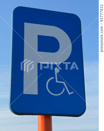Vertical shot on a blue panel for reserved parking spots for disabled people 93777832