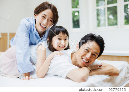 父母和孩子在床上消磨時光 93779253