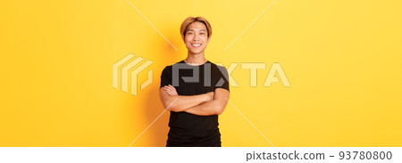 Portrait of confident handsome asian man smiling satisfied, standing over yellow background in black clothes Portrait of confident handsome asian man smiling satisfied, standing over yellow background in black clothes 93780800