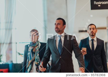 Photo of a business team in suits walking in a modern corporation. Successful business team. Selective focus Photo of a business team in suits walking in a modern corporation. Successful business team. Selective focus 93781908