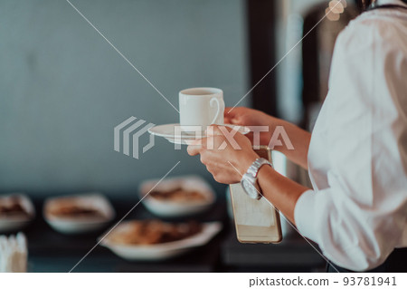 Close-up photo of businesswoman serving themselves in a modern hotel during a dinner party. Selective focus  93781941