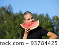 Young girl holding watermelon on nature background 93784425