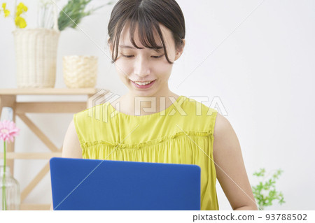 A lady who uses a laptop in the living room A lady who uses a laptop in the living room 93788502