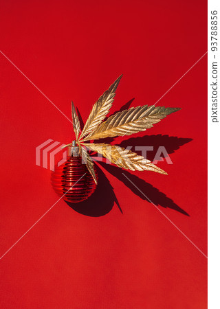 Red Christmas ball with a golden marijuana, cannabis leaf on red background Red Christmas ball with a golden marijuana, cannabis leaf on red background 93788856