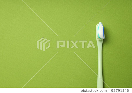 Toothbrush with toothpaste on green background, space for text 93791346