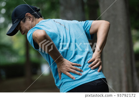 Middle male runner with back pain 93792172