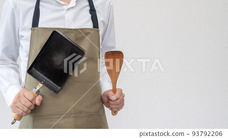 A man wearing an apron | Image of a man doing housework and cooking 93792206