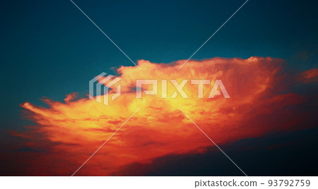 A setting sun colors a white cumulus cloud in explosive hues of dark red, orange and yellow. 93792759