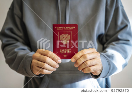 Russian passport in the hands of a man. Prohibition of Schengen visas for Russian tourists to travel to the European Union concept. 93792870