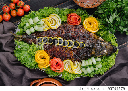 baked carp with vegetables close-up in a baking dish on the table baked carp with vegetables close-up in a baking dish on the table 93794579