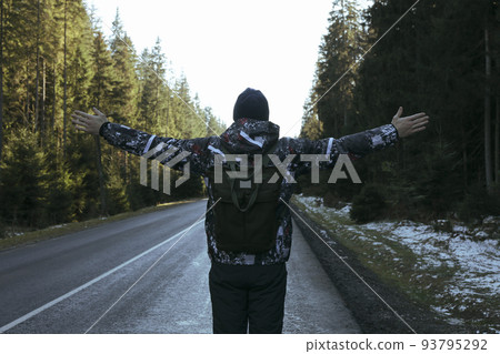 Man with spread hands standing on road 93795292