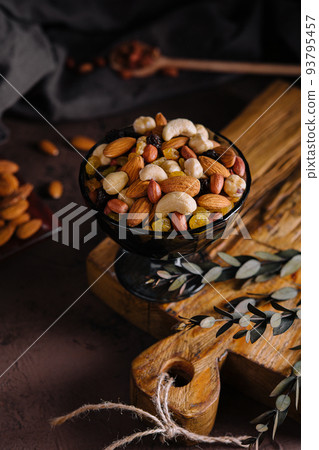Bowl with mixed organic nuts on wooden board Bowl with mixed organic nuts on wooden board 93795457