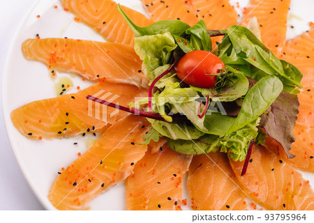 Slices of raw salmon fillet on white plate 93795964