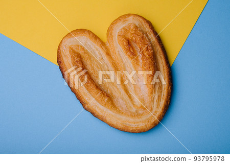Puff pastry cookies on blue and yellow background Puff pastry cookies on blue and yellow background 93795978