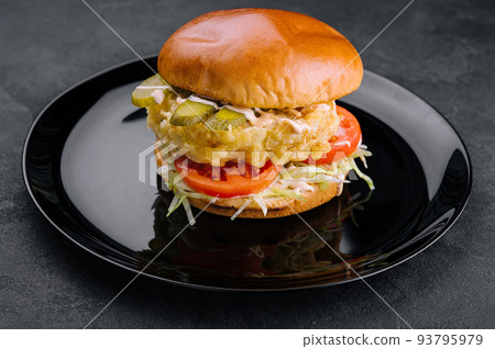Fried fish fillet burger on black plate Fried fish fillet burger on black plate 93795979