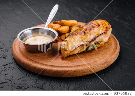 Fried chicken served with sauce and garnish on wooden board Fried chicken served with sauce and garnish on wooden board 93795982