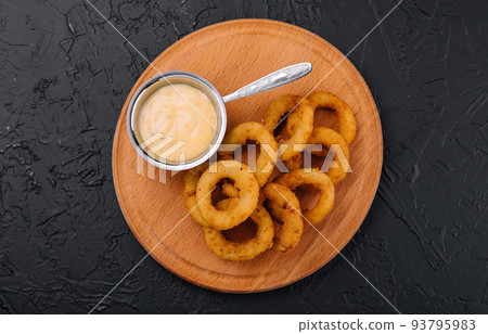 crunchy fried onion rings and sauce on wooden dish crunchy fried onion rings and sauce on wooden dish 93795983