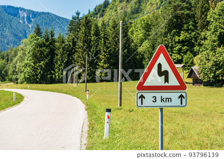 Triangular Road Sign of Winding Roads Ahead - Road with Dangerous Curves Triangular Road Sign of Winding Roads Ahead - Road with Dangerous Curves 93796139