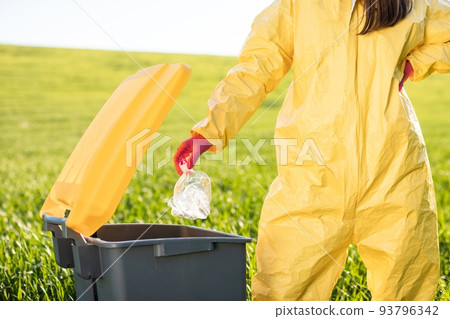 Close up woman's hand throwing away plastic bottle in nature. Environmental damage by plastic waste. Environmental conservation Close up woman's hand throwing away plastic bottle in nature. Environmental damage by plastic waste. Environmental conservation 93796342