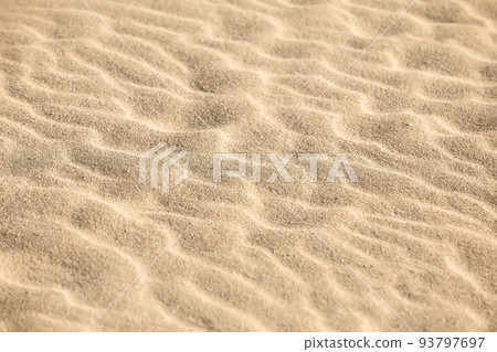 Sand on the beach as a background. Close-up sand texture. Summer sunlight. Top view. 93797697