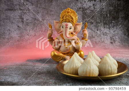 Idol of lord Ganesha with Modak Sweet Dish and flower. Ganesh chaturthi Idol of lord Ganesha with Modak Sweet Dish and flower. Ganesh chaturthi 93798459