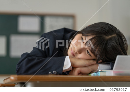 A high school girl who is worried about lying down on her desk during school breaks A high school girl who is worried about lying down on her desk during school breaks 93798917