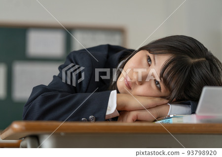 A high school girl who is worried about lying down on her desk during school breaks A high school girl who is worried about lying down on her desk during school breaks 93798920