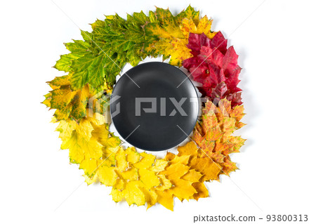 Autumn table setting with bright colorful leaves and black plate. Flat lay. Autumn table setting with bright colorful leaves and black plate. Flat lay. 93800313