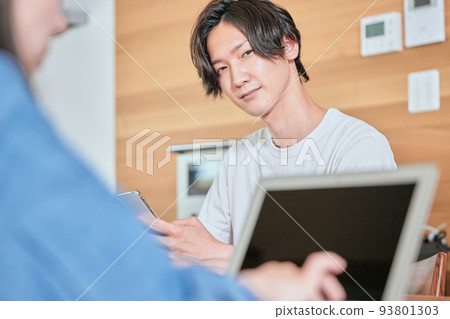 A young man operating a smartphone during telework A young man operating a smartphone during telework 93801303