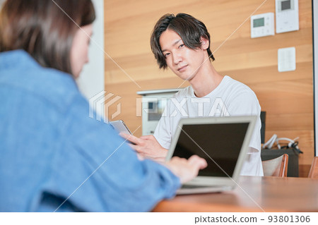 A young man operating a smartphone during telework A young man operating a smartphone during telework 93801306