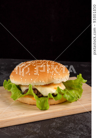 Burger with beef patty on a wooden plate 93801850