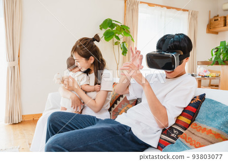 Family wearing VR goggles in the living room Family wearing VR goggles in the living room 93803077