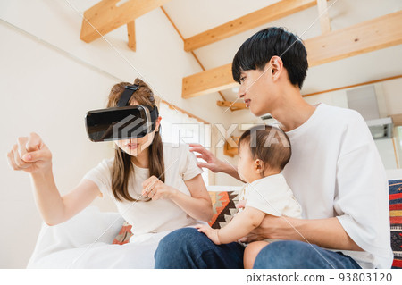 Family wearing VR goggles in the living room 93803120