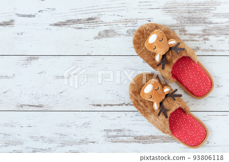 Cozy Christmas slippers on wooden parquet top view. 93806118