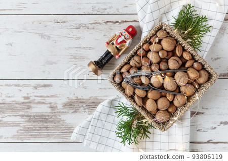 Variety of shelled nuts and nutcracker on wooden background top view. 93806119