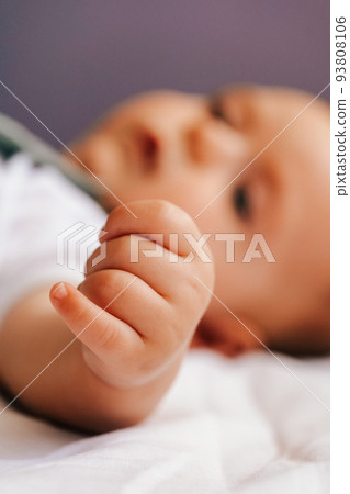 closeup of cute tender hand fingers of baby lying on the bed closeup of cute tender hand fingers of baby lying on the bed 93808106