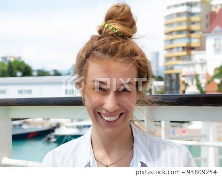 Smiling girl close-up. Blurred city background. The wind blows on your face Smiling girl close-up. Blurred city background. The wind blows on your face 93809254