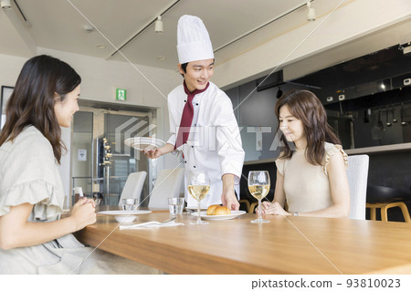 Parents and children eating at a restaurant and a chef carrying food Parents and children eating at a restaurant and a chef carrying food 93810023