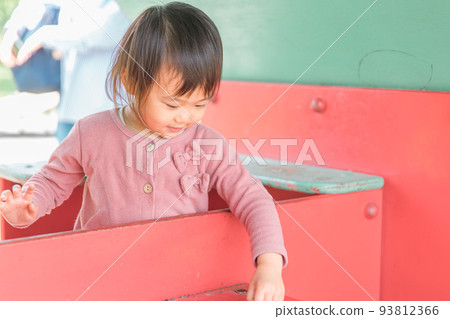 Child (girl) playing with playground equipment in the park Child (girl) playing with playground equipment in the park 93812366