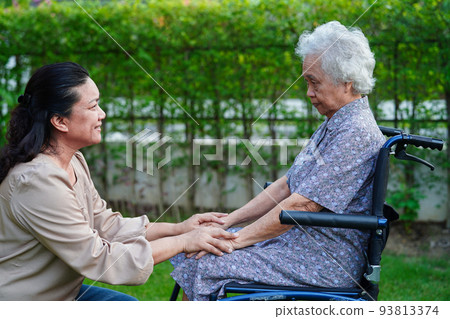 Caregiver help Asian elderly woman disability patient sitting on wheelchair in park, medical concept. Caregiver help Asian elderly woman disability patient sitting on wheelchair in park, medical concept. 93813374