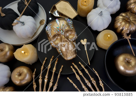 Creative photo with a golden skull and a luxurious table setting  93813885