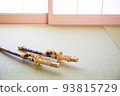 A short Japanese sword placed in a Japanese-style room with shoji screens 93815729