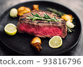 delicious steak on black plate served with rosemary 93816796