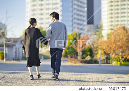 一對穿著外套手牽手散步的夫婦的背影 93817475