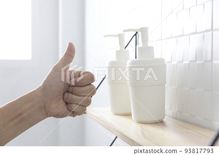 Hand sanitizer and face masks on a shelf with human hand. Coronavirus COVID-19 hand hygiene prevention.th care concept 93817793