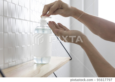 Hand sanitizer and face masks on a shelf with human hand. Coronavirus COVID-19 hand hygiene prevention.th care concept 93817797