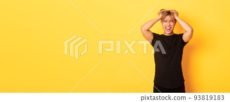 Portrait of pissed-off angry asian man tossing haircut and yelling furious, standing over yellow background Portrait of pissed-off angry asian man tossing haircut and yelling furious, standing over yellow background 93819183